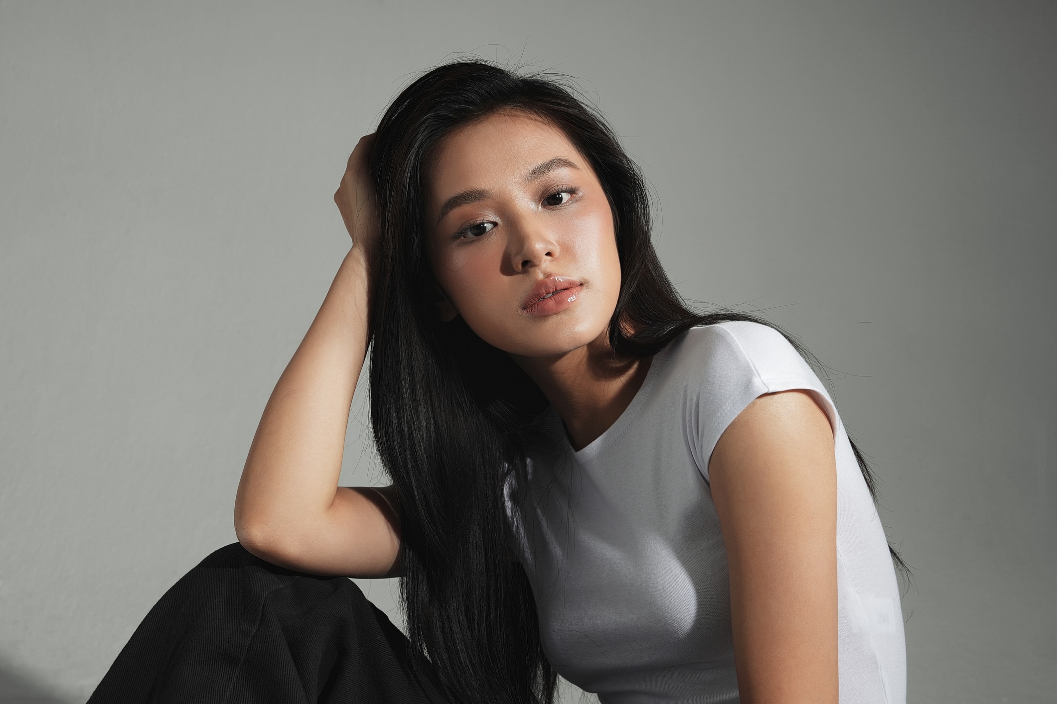 Young woman with long hair posing thoughtfully.